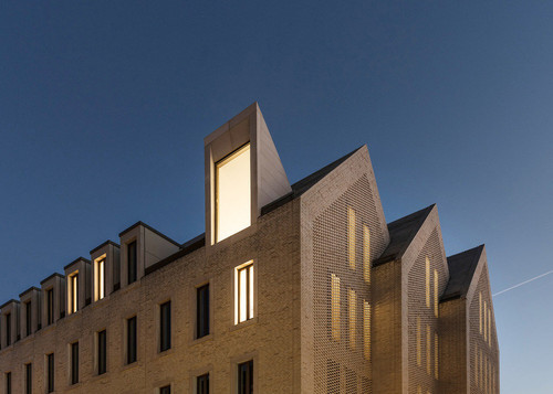 Okna dachowe biblioteki i schodkowe szczyty z częściowo perforowaną cegłą. | Zdjęcie: Franco Casaccia / JSWD 